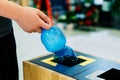 Selective focus close up hand throwing an empty plastic bottle in the recycling garbage trash or bin Royalty Free Stock Photo