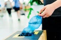 Selective focus close up hand throwing an empty plastic bottle in the recycling garbage trash or bin Royalty Free Stock Photo