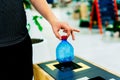 Selective focus close up hand throwing an empty plastic bottle in the recycling garbage trash or bin Royalty Free Stock Photo