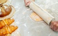 Selective focus and close up on hands using rolling pin to teach and thresh dough flour to make pie and bread for serving on table Royalty Free Stock Photo