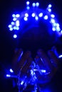 Selective focus. Close-up photo of woman\'s hands with fairy garlands lights. Merry Christmas and Happy new year. Royalty Free Stock Photo