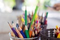 Selective focus and close up shot with copy space of many multi-colored pencils standing in the case in bright sunlight shows Royalty Free Stock Photo
