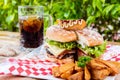 Selective focus closeup of a burger on a plate and a glass of lemon iced tea Royalty Free Stock Photo