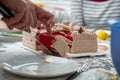 Selective focus closeup of a pair of hand slicing the birthday cake on the table