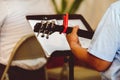 Selective focus closeup of a person playing the guitar while looking at a music sheet Royalty Free Stock Photo