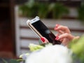 Selective focus closeup shot of a female with red nail polish holding a rose gold phone Royalty Free Stock Photo