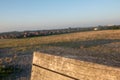 Selective focus closeup shot of a wooden bench on a grass field during a sunset Royalty Free Stock Photo