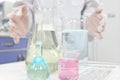 Selective focus of colorful liquid chemicals in glass beaker, flask and tube with scientist hands working. Chemistry Laboratory.
