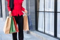 Selective focus at colorful shopping bags. Women carry many shopping back and walking out from fashion department store. End of Royalty Free Stock Photo