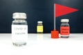 Selective focus Covid-19 vaccine vial beside a red flag. Coronavirus vaccine candidate development race and competition concept. Royalty Free Stock Photo