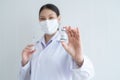 Selective focus on Covid-19 vaccines vial bottle in hand of Asian young scientist woman wear face mask and holding syringe Royalty Free Stock Photo