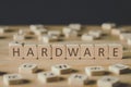 Focus of cubes with word hardware surrounded by blocks with letters on wooden surface isolated on black