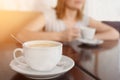 Selective focus on a cup with aromatic coffee. Blurred background with girl drinking coffee cup Royalty Free Stock Photo
