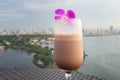 Selective focus on cup of juice fruit against aerial scene of cityscape with lake. Concept of leisure time having drink outdoor, o Royalty Free Stock Photo