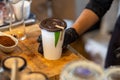 selective focus. dark brown lid decorated White paper coffee cup fragrant green pandan leaves. The green color makes it look like