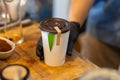 selective focus. dark brown lid decorated White paper coffee cup fragrant green pandan leaves. The green color makes it look like