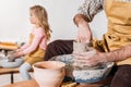 selective focus of daughter making ceramic pot on pottery wheel with father Royalty Free Stock Photo