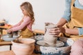 selective focus of daughter making ceramic pot on pottery wheel with mother Royalty Free Stock Photo