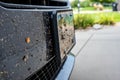 Selective focus on dead bugs splattered to the front grill and plates of a vehicle Royalty Free Stock Photo