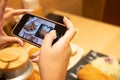 Selective focus at device screen. Women hand using smartphone to take photo of Japanese food for send or share with her friend or