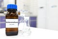 Selective focus of dichloromethane liquid chemical compound in dark glass bottle inside a chemistry laboratory with copy space. Royalty Free Stock Photo