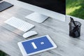 selective focus of digital tablet with facebook website and computer with blank screen at table Royalty Free Stock Photo