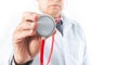 Selective focus of a doctor holding in his hand a red stethoscope to check heart and lungs Royalty Free Stock Photo