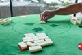 Selective focus on the domino pieces in the foreground. In the background, man starts the game