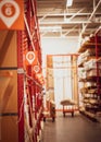 Selective focus door windows moulding millwork parts on metal rack shelving with bay number, lumber cart at home improvement