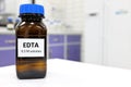 Selective focus of EDTA liquid chemical compound reagent solution in dark glass bottle inside a chemistry laboratory. Royalty Free Stock Photo