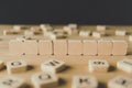 Focus of eight blank cubes surrounded by blocks with letters on wooden surface isolated on black