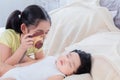 Selective focus elder sister teasing newborn baby while sleeping on bed. Happy adorable girl using toy camera take a photo little Royalty Free Stock Photo