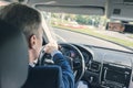 Selective focus of elderly man hands on steering wheel driving a car on the speed highway. View from above. Royalty Free Stock Photo