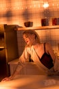 selective focus of elegant housewife leaning over counter while cooking in kitchen