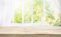 selective focus.Empty of wood table top on blur of curtain window and abstract green from garden with sunlight .For montage Royalty Free Stock Photo