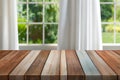 Empty of wood table top on blur of curtain with window and green from garden background. Royalty Free Stock Photo