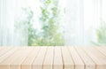 Selective focus.Empty of wood table top on blur of curtain with window and green from garden background