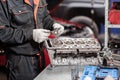 Selective focus. Engine Block on a repair stand with Piston and Connecting Rod of Automotive technology. Blurred red car