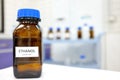 Selective focus of ethanol or ethyl alcohol brown amber glass bottle inside a laboratory. Blurred background with copy space.