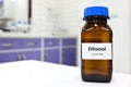 Selective focus of ethanol or ethyl alcohol in brown glass bottle inside a laboratory.