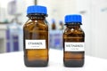 Selective focus of ethanol and methanol brown amber glass bottle inside a laboratory. Blurred background with copy space. Royalty Free Stock Photo