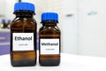 Selective focus of ethanol and methanol in brown glass bottle container. White laboratory background with copy space.