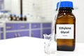 Selective focus of ethylene glycol liquid chemical compound in dark glass bottle inside a chemistry laboratory with copy space.