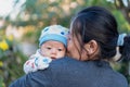 Selective focus on eyes of adorable newborn baby child boy resting in mother`s arms at park