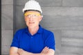 Selective focus at face of Caucasian foreman at building construction site, wearing protective hat and safety equipment while