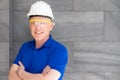 Selective focus at face of Caucasian foreman at building construction site, wearing protective hat and safety equipment while