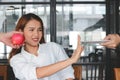 Selective focus on face of young Asian woman choosing between apple or unhealthy cake. Healthy lifestyle and dieting concept. Royalty Free Stock Photo