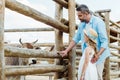 selective focus of father and kid standing near wooden fence with bison in zoo.