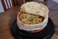 Selective focus of a flat bread stuffed with spaghetti pasta with greens and cheese Royalty Free Stock Photo