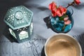 Selective focus flat lay view of bowl of coffee, lighted lantern, and small vase of flowers Royalty Free Stock Photo